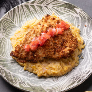 Tilápia em crosta farinha de amendoas com purê de banana da terra e vinagrete